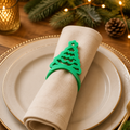 Rond de serviette Sapin de Noël vert présenté sur une serviette de table